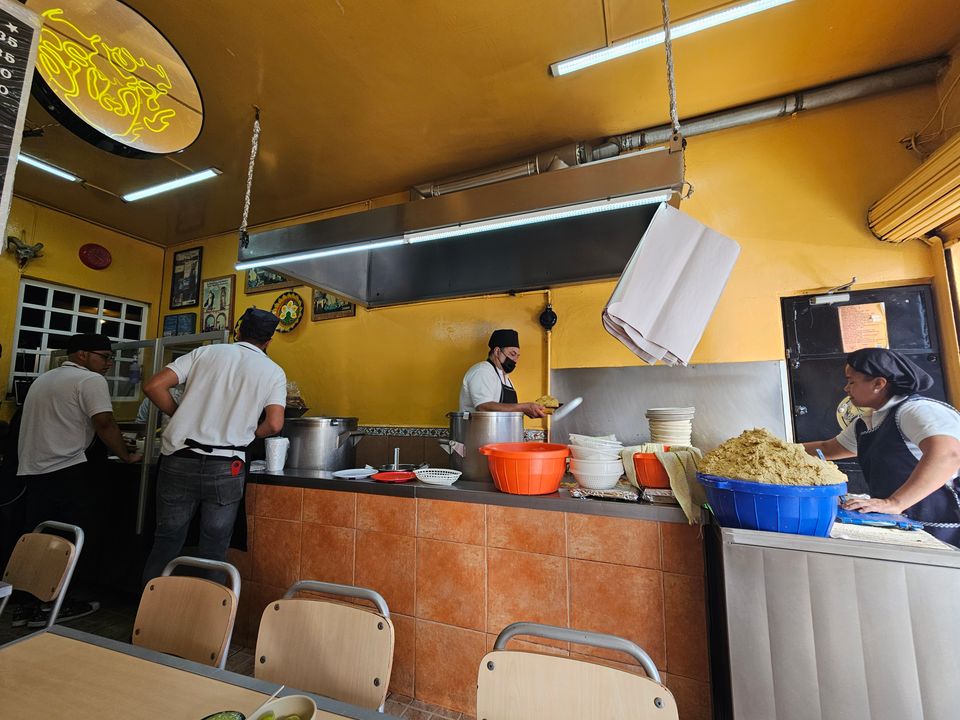 La cocina en servicio: el equipo sirviendo de las ollas y la masa lista para echar tortillas a mano